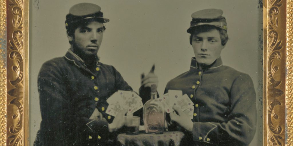 Two soldiers pose with a whiskey bottle. Courtesy of the Library of Congress